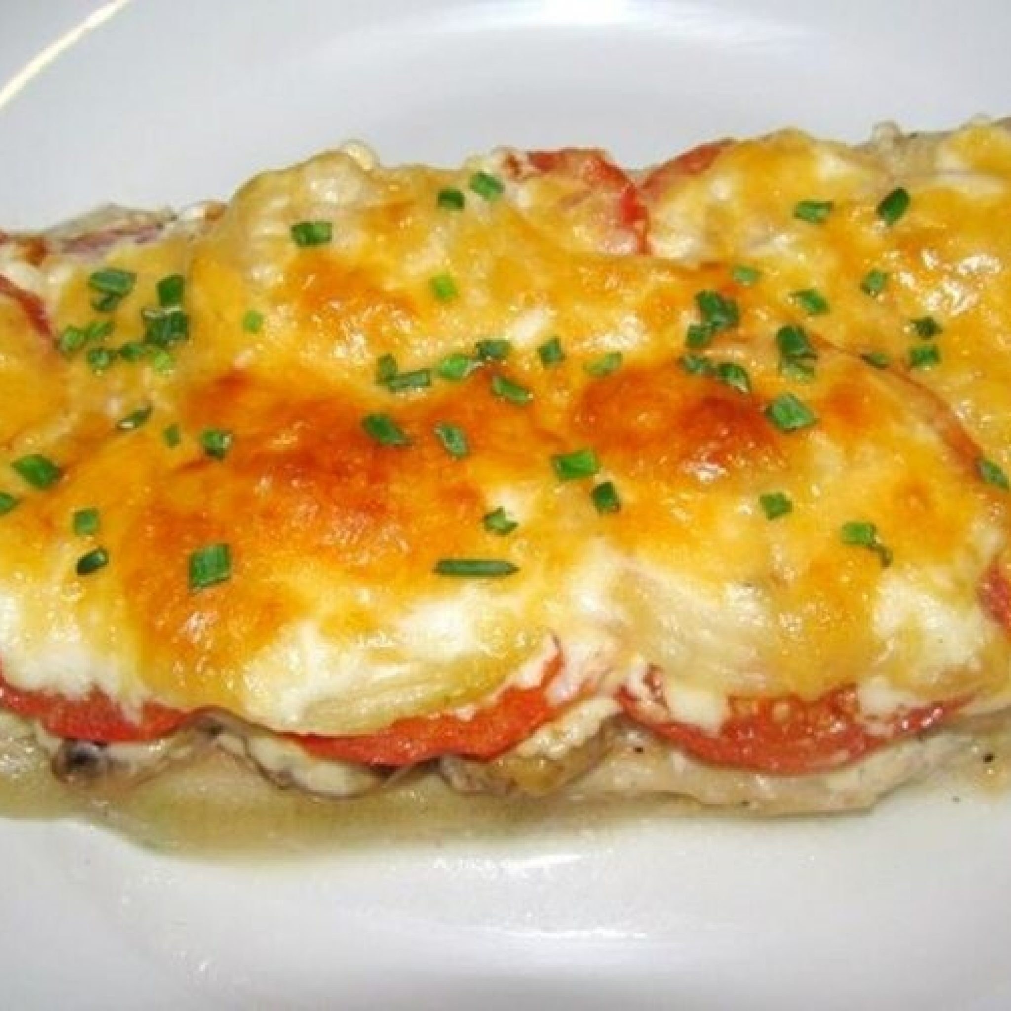 Филе минтая с помидорами и сыром. Минтай с помидорами и сыром в духовке. Минтай запеченный с помидорами и сыром. Рыба под сырной корочкой в духовке. Рыба под сырной шапкой.