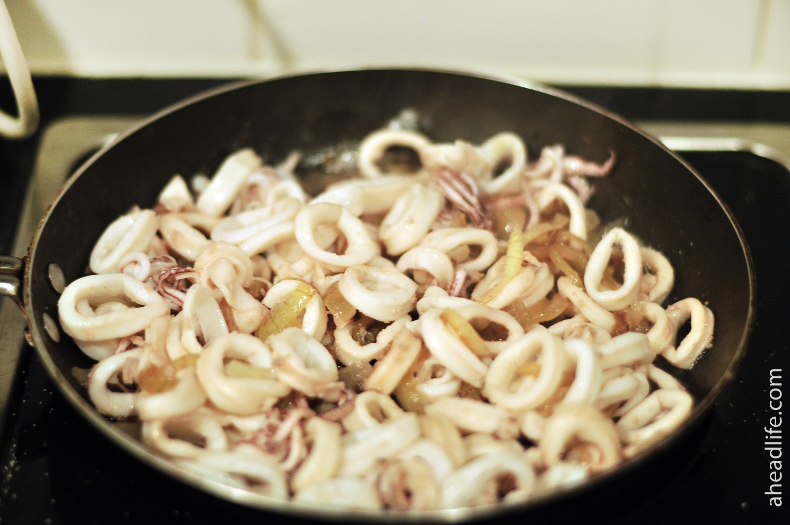 Простой рецепт кальмаров на сковороде. Кальмар на сковороде. Кальмар жареный с луком. Жареные кальмары на сковороде с луком. Вкусные кальмары на сковороде.