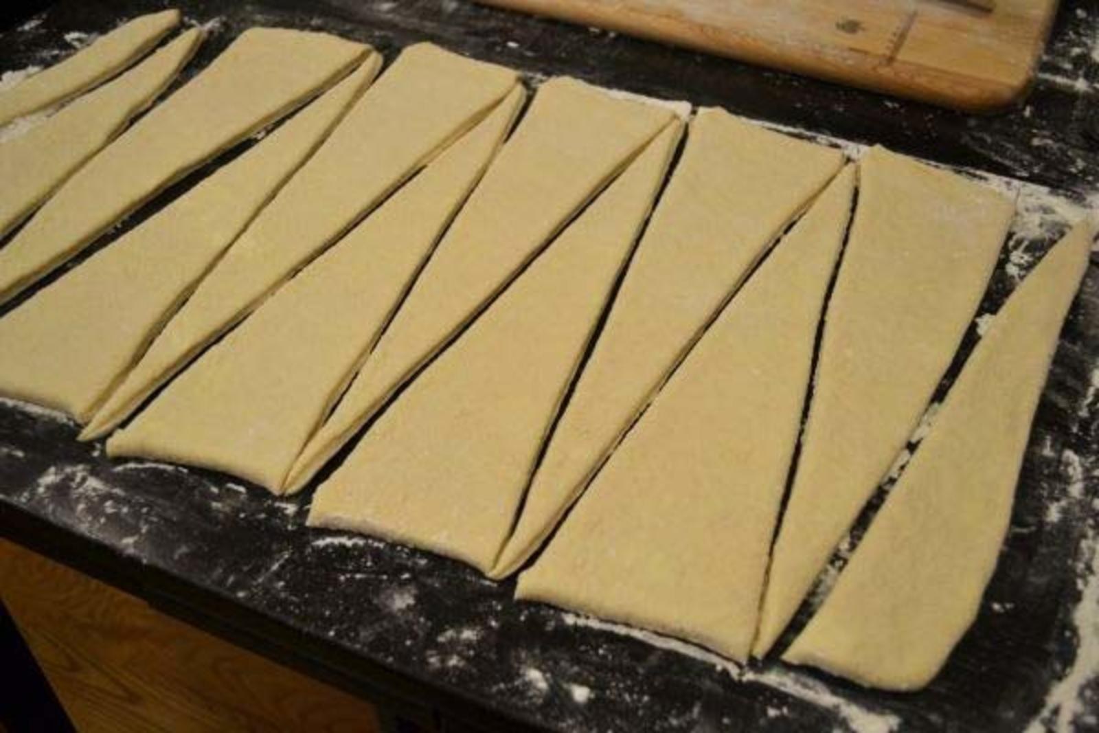 Слоеное тесто нужно раскатывать. Разрезать тесто на круассаны. Круассаны из слоеного теста. Порезать тесто для круассанов. Готовое слоеное тесто круассаны.
