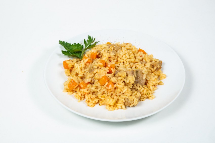 Плов с курицей в тарелке на столе