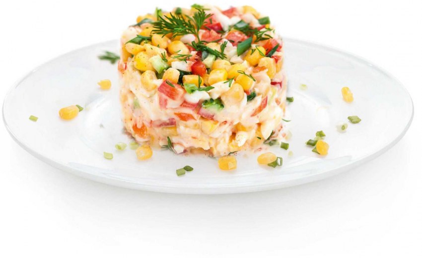 Салат с крабовыми палочками и кукурузой на белом фоне