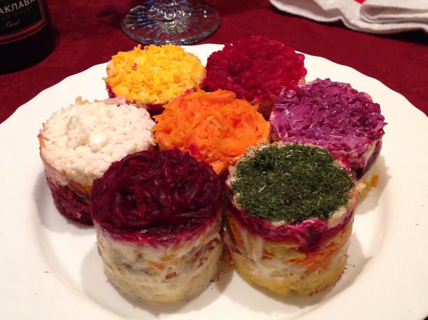 Traditional Russian Herring under a fur Coat in transparent Plate with parsley. Rustic Style. Christmas Russian Salad.