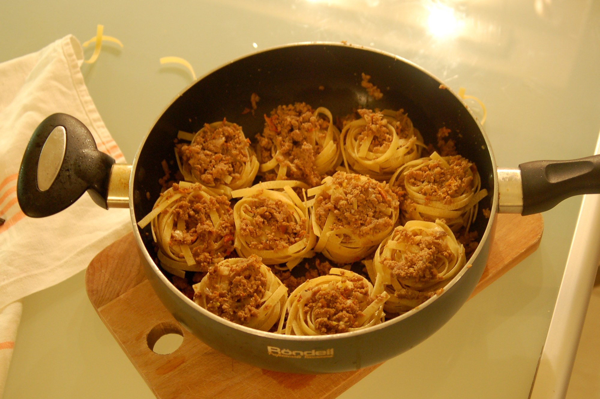 Макароны гнезда на сковороде в соусе. Гнёзда с фаршем на сковороде. Спагетти гнезда с фаршем. Гнезда с тефтелями на сковороде. Макароны с фаршем на сковороде.