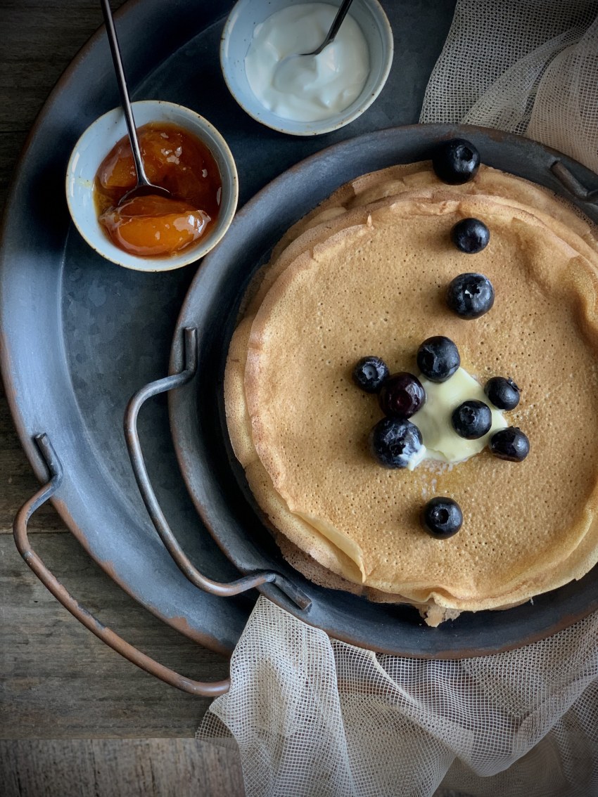 Блины со сметаной на белом фоне
