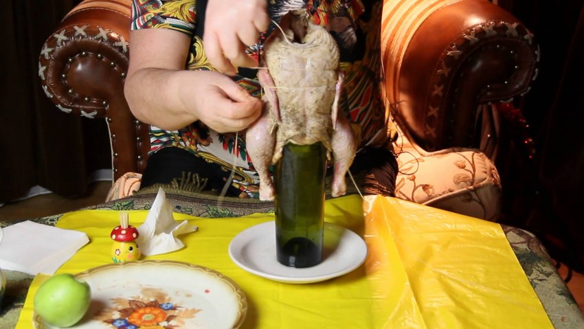 Курица на бутылке с овощами в духовке