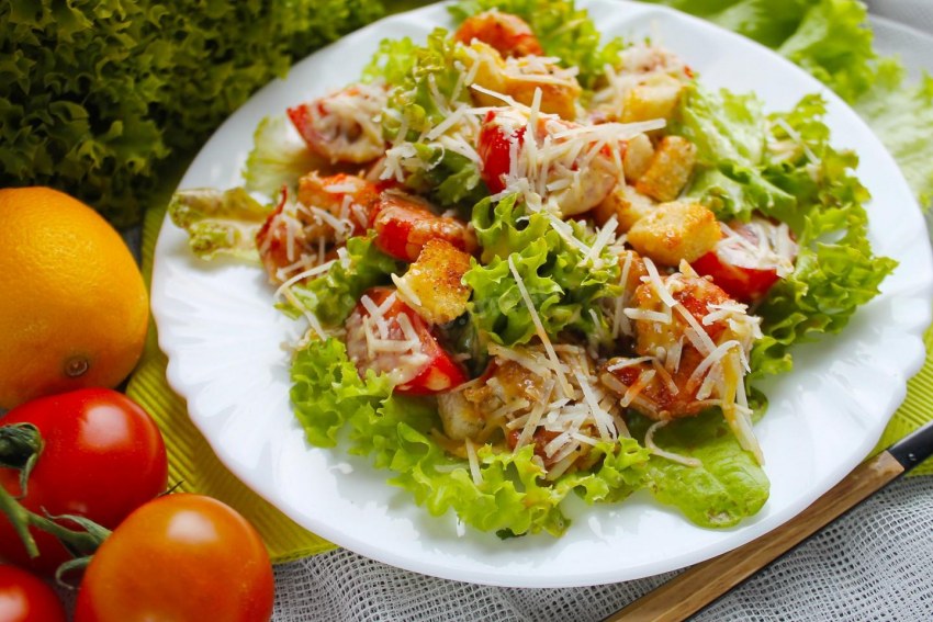 Салат Цезарь с курицей на белом фоне