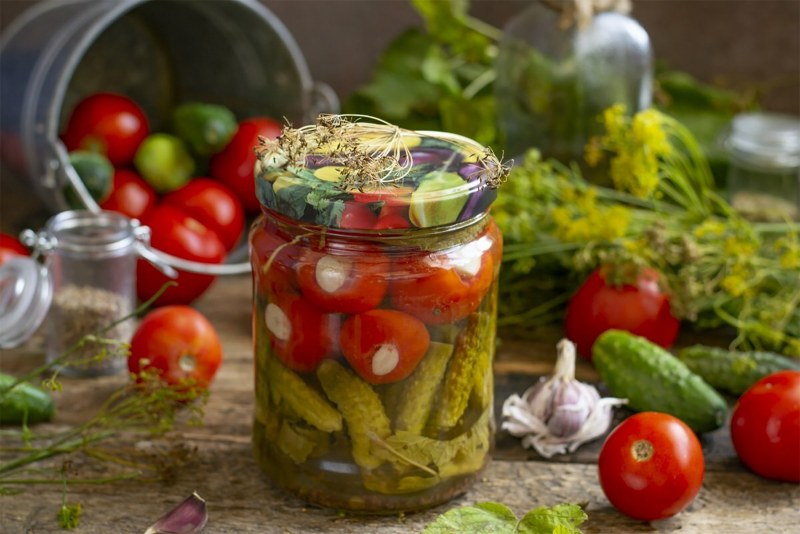 Маринованные овощи в банке на черном фоне