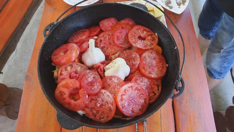 Блюдо в казане с капустными листьями мясом и овощами